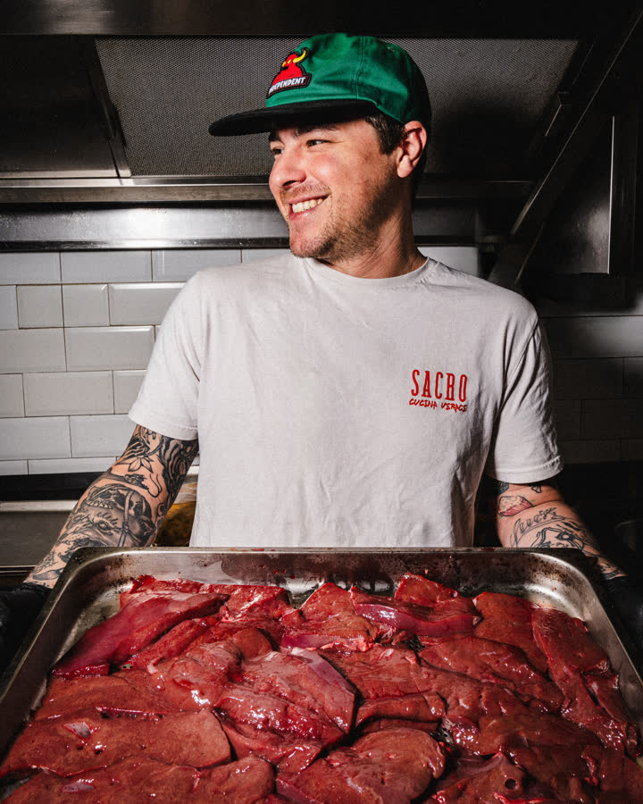 uno chef sorridente con un vassoio di carne